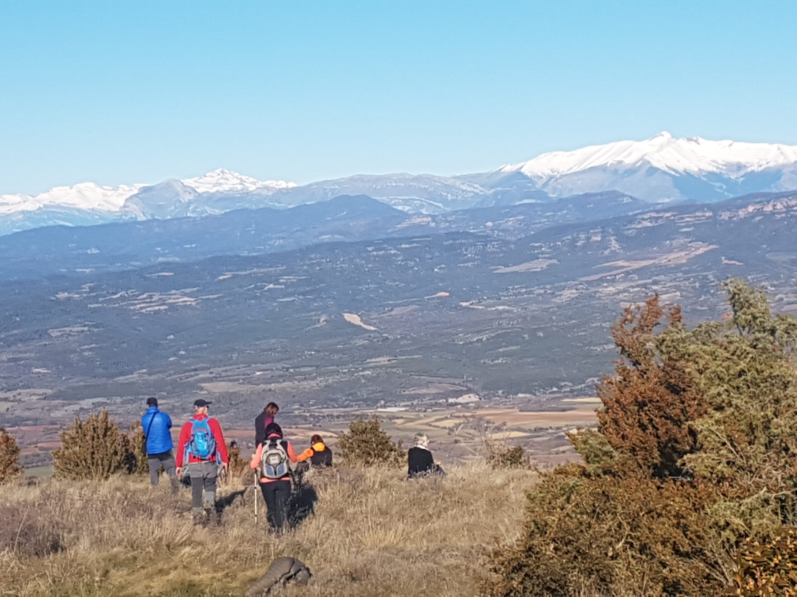 Wandelvakantie Pyreneeën deelnemers op bergpad met uitzicht op de vallei kijkend naar de drie duizenders
